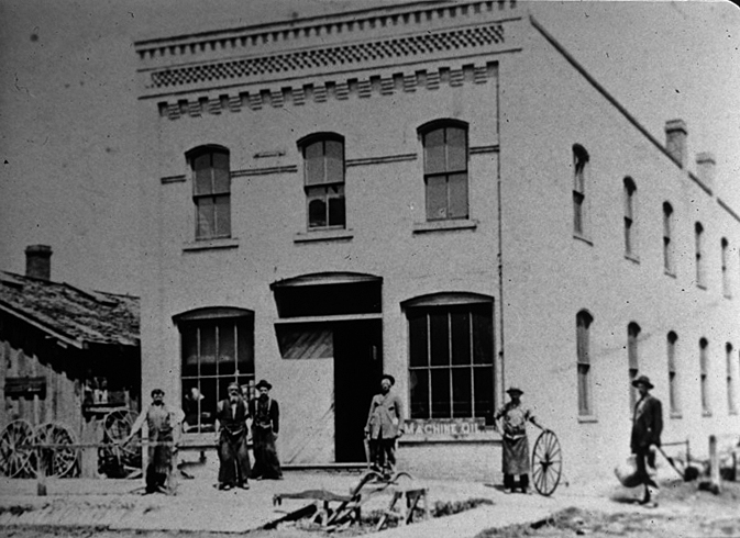 Men in front of the Laube & Durner Blacksmith Shop as described in the article. From left are Jack Mulvihill, John Laube, Joe Laube, unknown customer, Antone Durner with wheel, & another unknown customer. This building still stands on the corner of East Exchange Street and East 2nd Avenue. Photo, BHS collection.